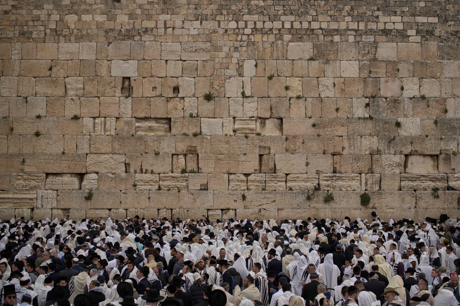 Covered in prayer shawls, Jewish men of the Cohanim Priestly caste participate in a blessing during the holiday of Passover, at the Western Wall, the holiest site where Jews can pray, in the Old City of Jerusalem, Tuesday, April 15, 2025. (AP Photo/Leo Correa)