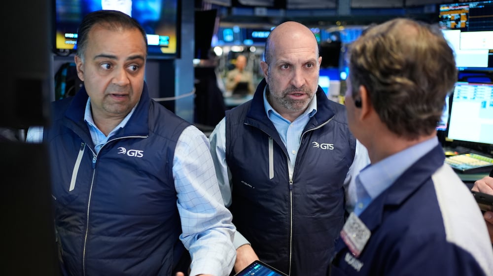 James Denaro, center, and Dilip Patel, left, work on the floor at the New York Stock Exchange in New York, Wednesday, March 25, 2026. (AP Photo/Seth Wenig)