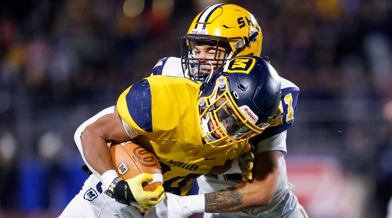 Moeller's Jordan Marshall is tackled by Springfield's Teryon Holt in the 2022 Division I state semifinals at Piqua. Michael Cooper/CONTRIBUTED