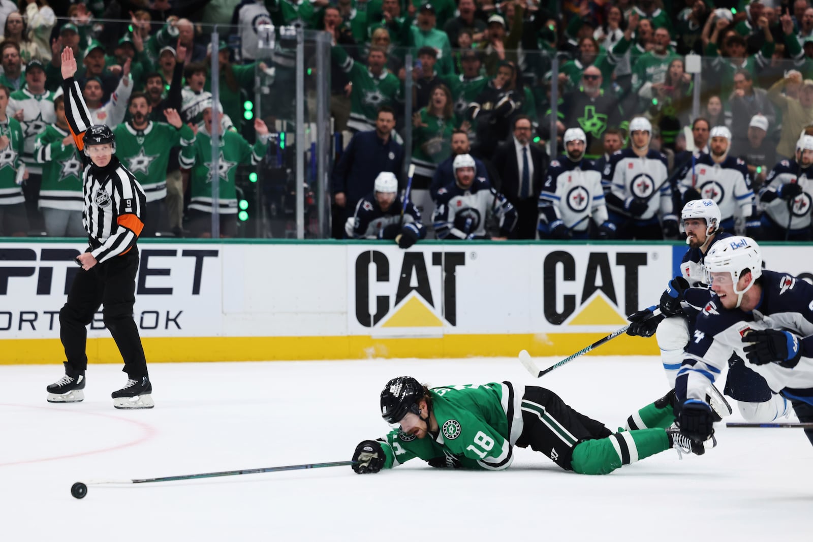 Dallas Stars center Sam Steel (18) is tripped by Winnipeg Jets' Mark Scheifele, right rear, on an attack in the third period of Game 6 of a second-round NHL hockey playoff series in Dallas, Saturday, May 17, 2025. (AP Photo/Gareth Patterson)