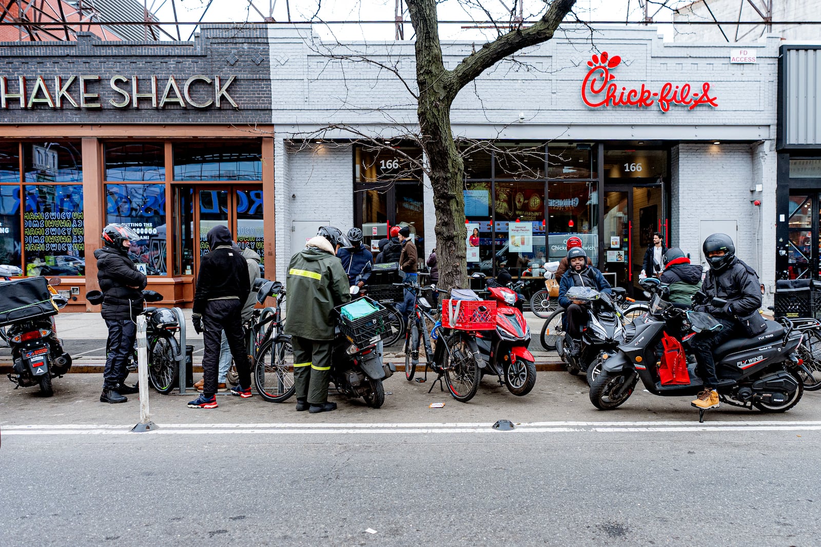 FILE - Delivery workers wait in front of restaurants for orders, Feb. 1, 2024, in New York. (AP Photo/Peter K. Afriyie, File)
