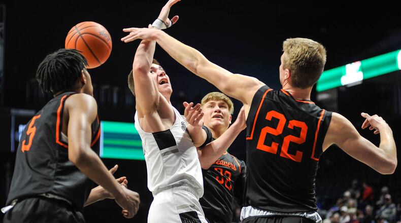 Lakota East's Alex Mangold is surrounded by Beavercreek palayersSiloam Baldwin (5), Gabe Phillips (32) and Adam Duvall (22) as he goes up for a shot during their Division I District basketball final Sunday, MArch 8, 2020 at Xavier University's Cintas Center.  Lakota East won 33-32.NICK GRAHAM / STAFF