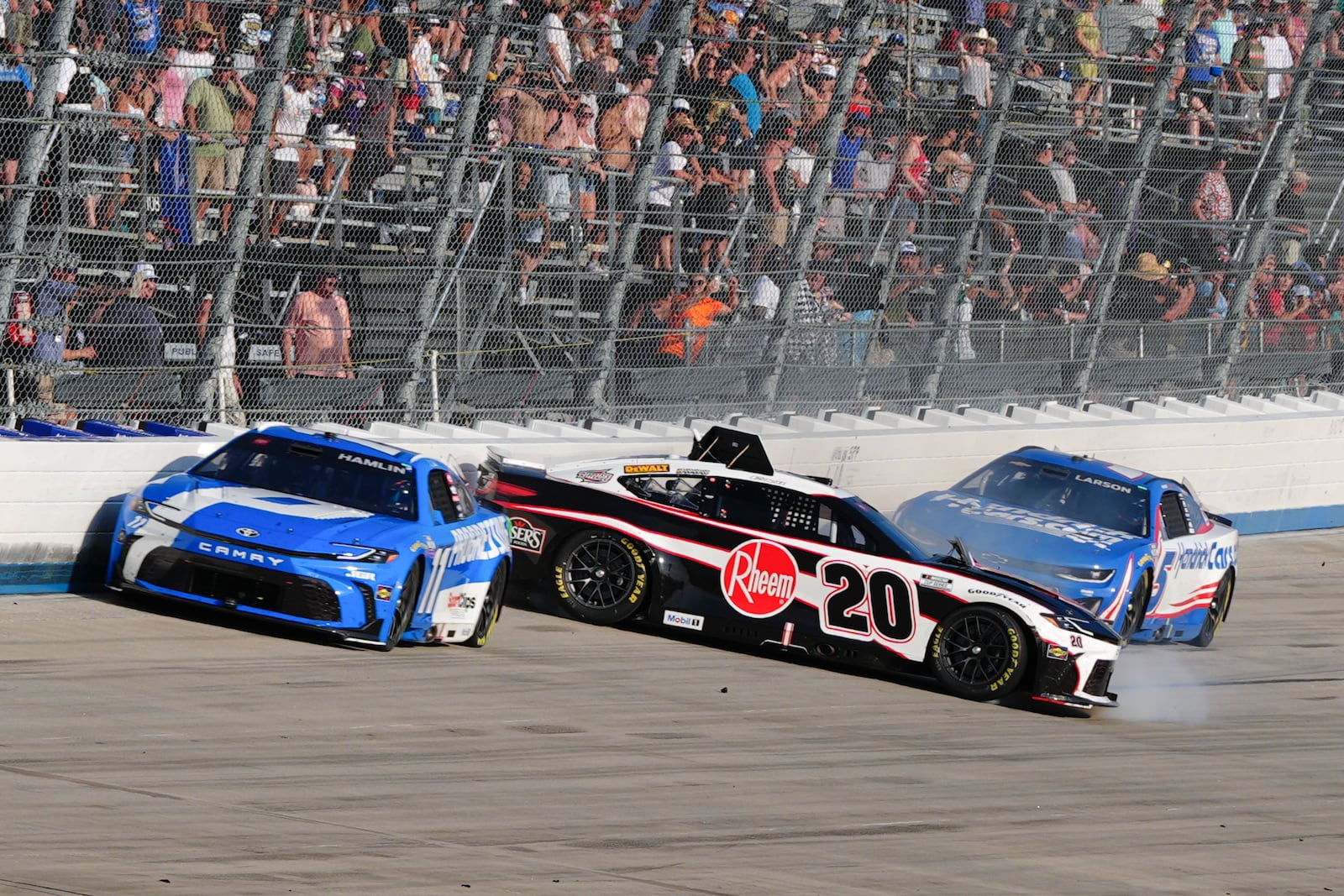 Christopher Bell (20) spins behind leader Denny Hamlin (11) during a NASCAR Cup Series auto race at Dover Motor Speedway, Sunday, July 20, 2025, in Dover, Del. (AP Photo/Derik Hamilton)