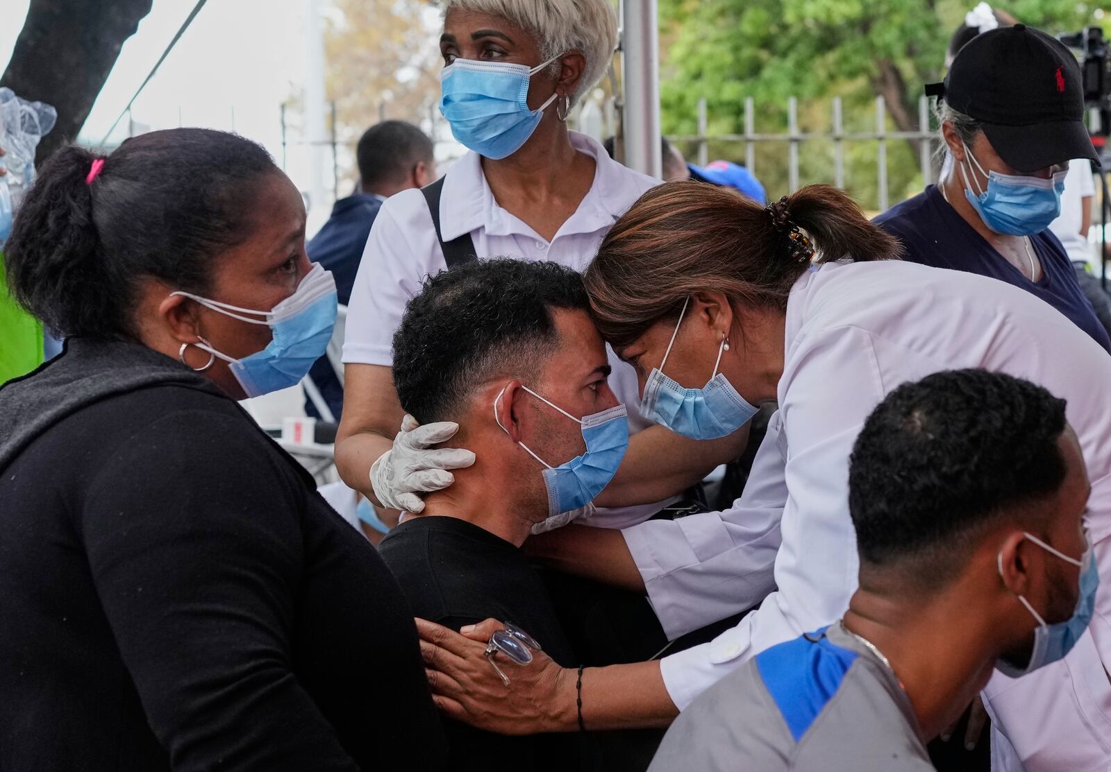 A person is comforted before identifying the body of a family member who died at the Jet Set nightclub, days after its roof collapsed during a concert and killed more than 200 people, outside the National Institute of Forensic Pathology in Santo Domingo, Dominican Republic, Thursday, April 10, 2025. (AP Photo/Matias Delacroix)