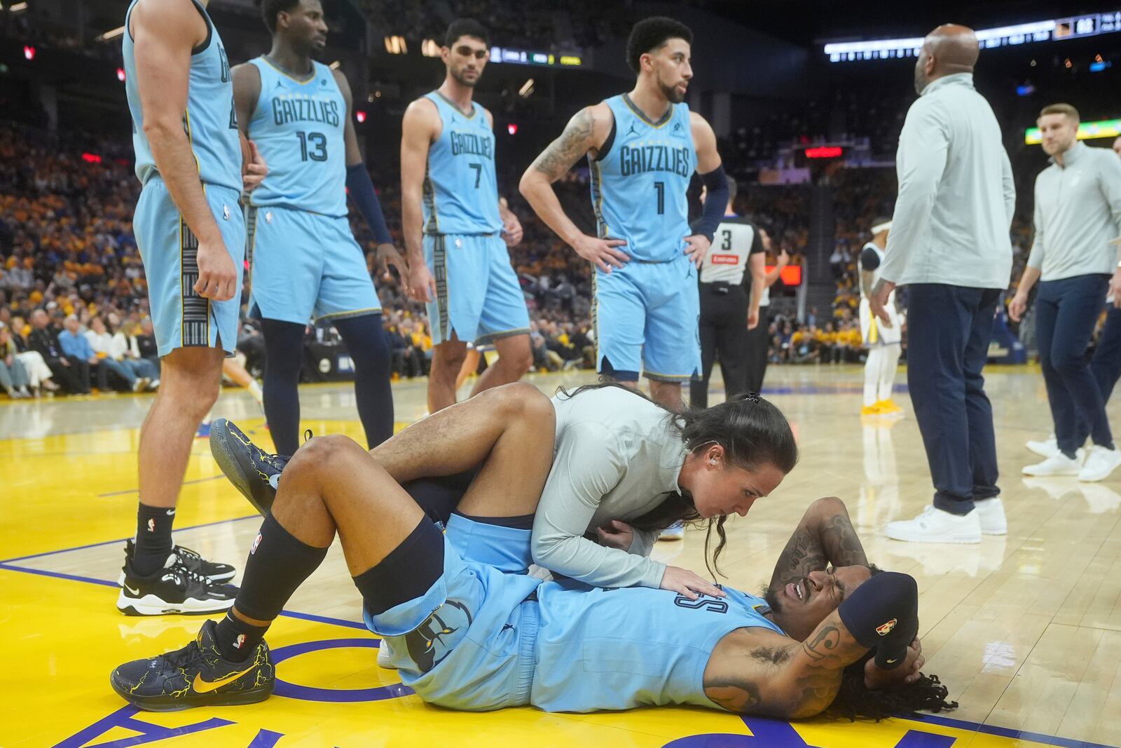 Memphis Grizzlies guard Ja Morant, bottom, reacts after hitting the floor during the second half of an NBA play-in tournament basketball game against the Golden State Warriors in San Francisco, Tuesday, April 15, 2025. (AP Photo/Jeff Chiu)