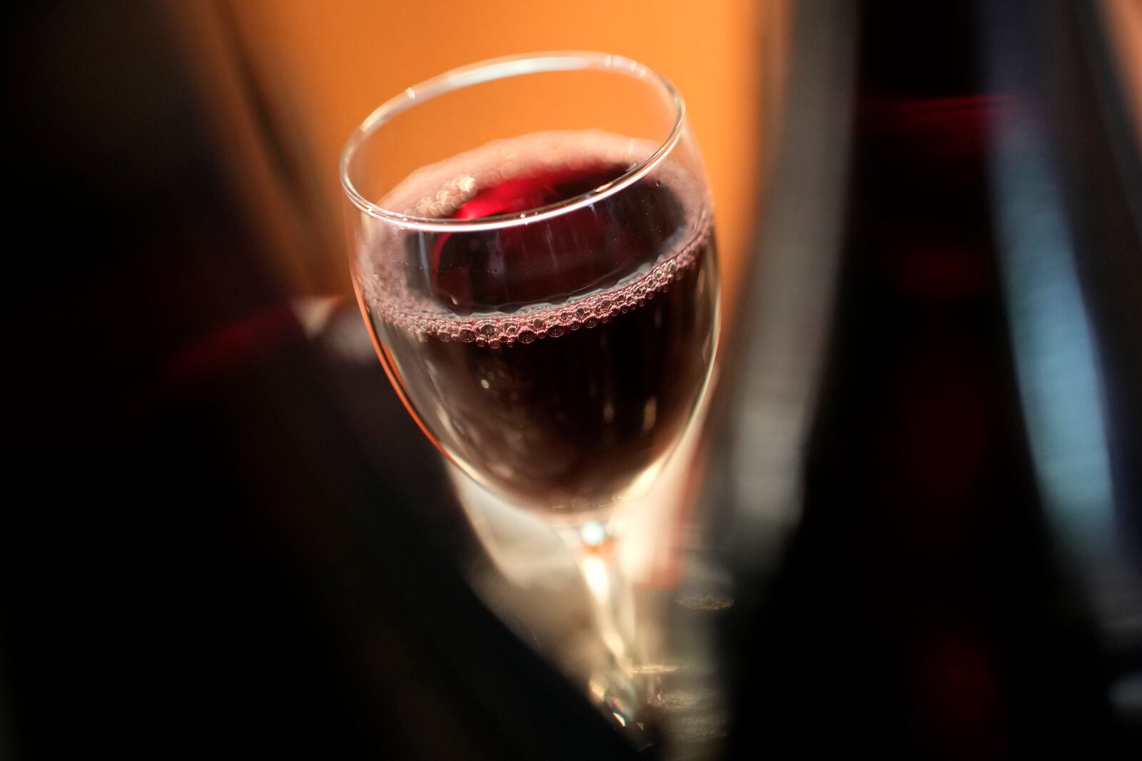 A glass of Beaujolais Nouveau wine is pictured in a restaurant of Boulogne Billancourt, outside Paris, Thursday, Nov. 18, 2021. Each year, on the third Thursday in November at the stroke of midnight, the world welcomes in the new Beaujolais Nouveau vintage, a light red wine, produced in the Beaujolais region of southern Burgundy. (AP Photo/Christophe Ena)