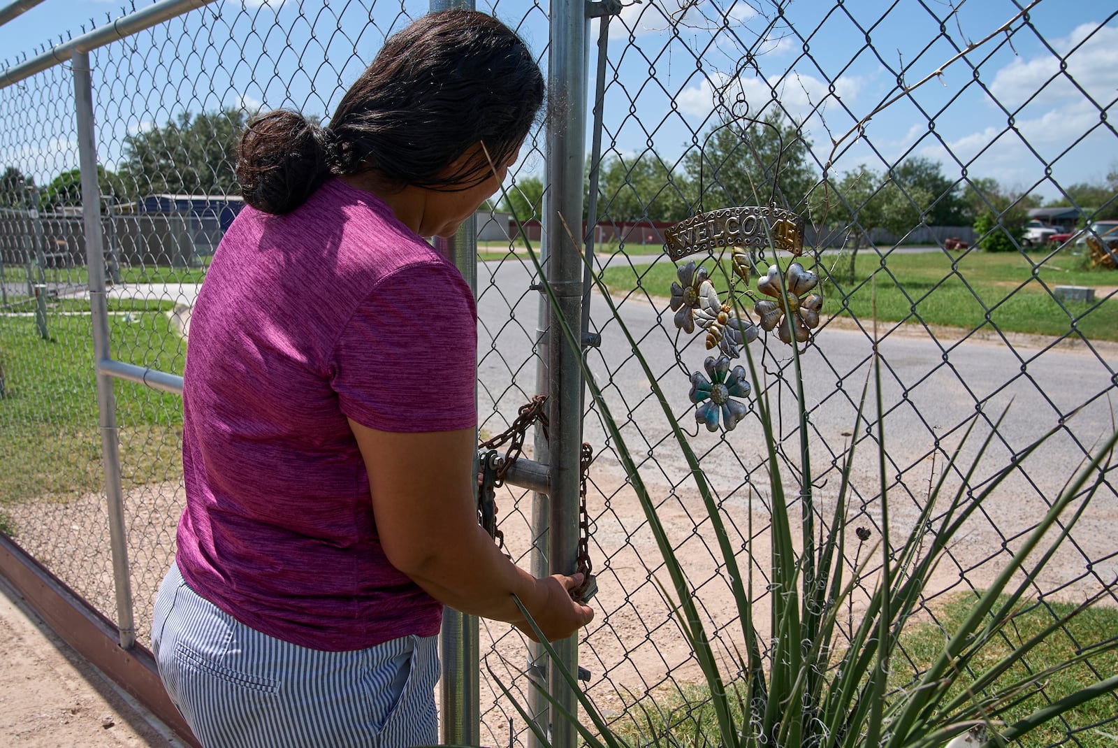 Terrified of being taken away from her children by ICE agents or police, Maria has begun locking her fence with a chain and padlock, Wednesday, June 18, 2025, at her home in Hidalgo County, Texas. (AP Photo/Jacquelyn Martin)