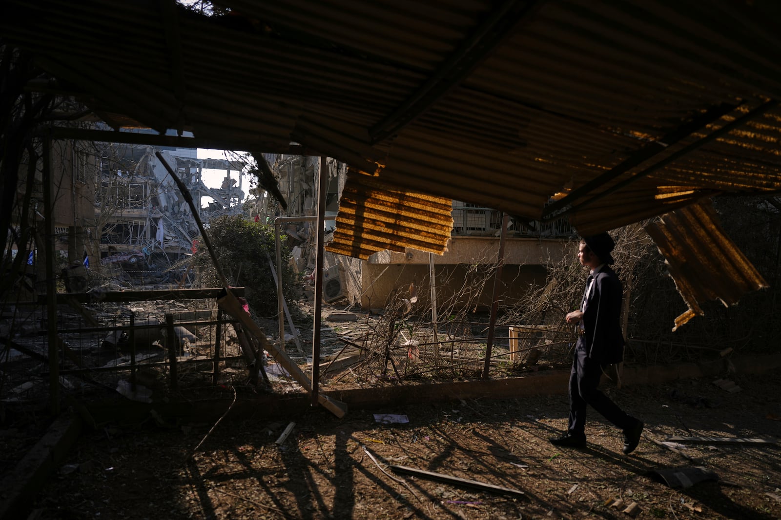 A person looks out at a destroyed residential building that was hit by a missile fired from Iran, in Ramat Gan, near Tel Aviv, Israel, on Saturday, June 14, 2025. (AP Photo/Ariel Schalit)
