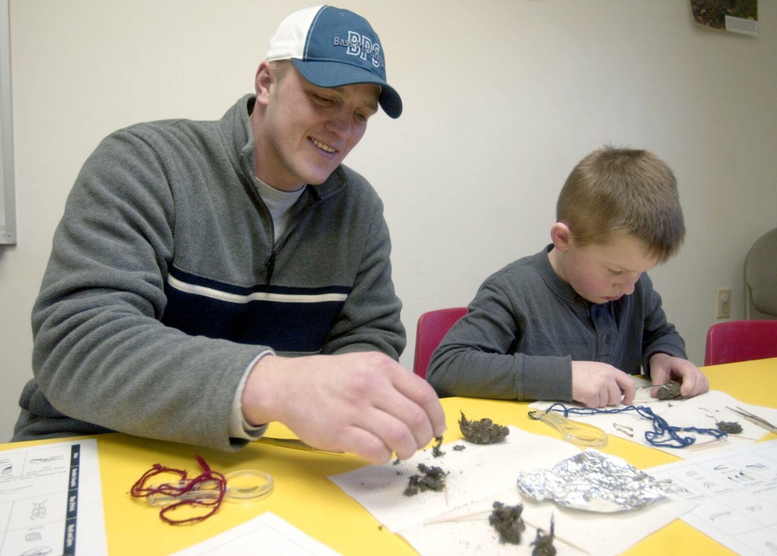 Barak Faulk and his son Barak, 5, dissect an owl pellet during a program about owls at the Germantown Metro Park Nature Center on Feb. 18, 2007. COX MEDIA FILE PHOTO