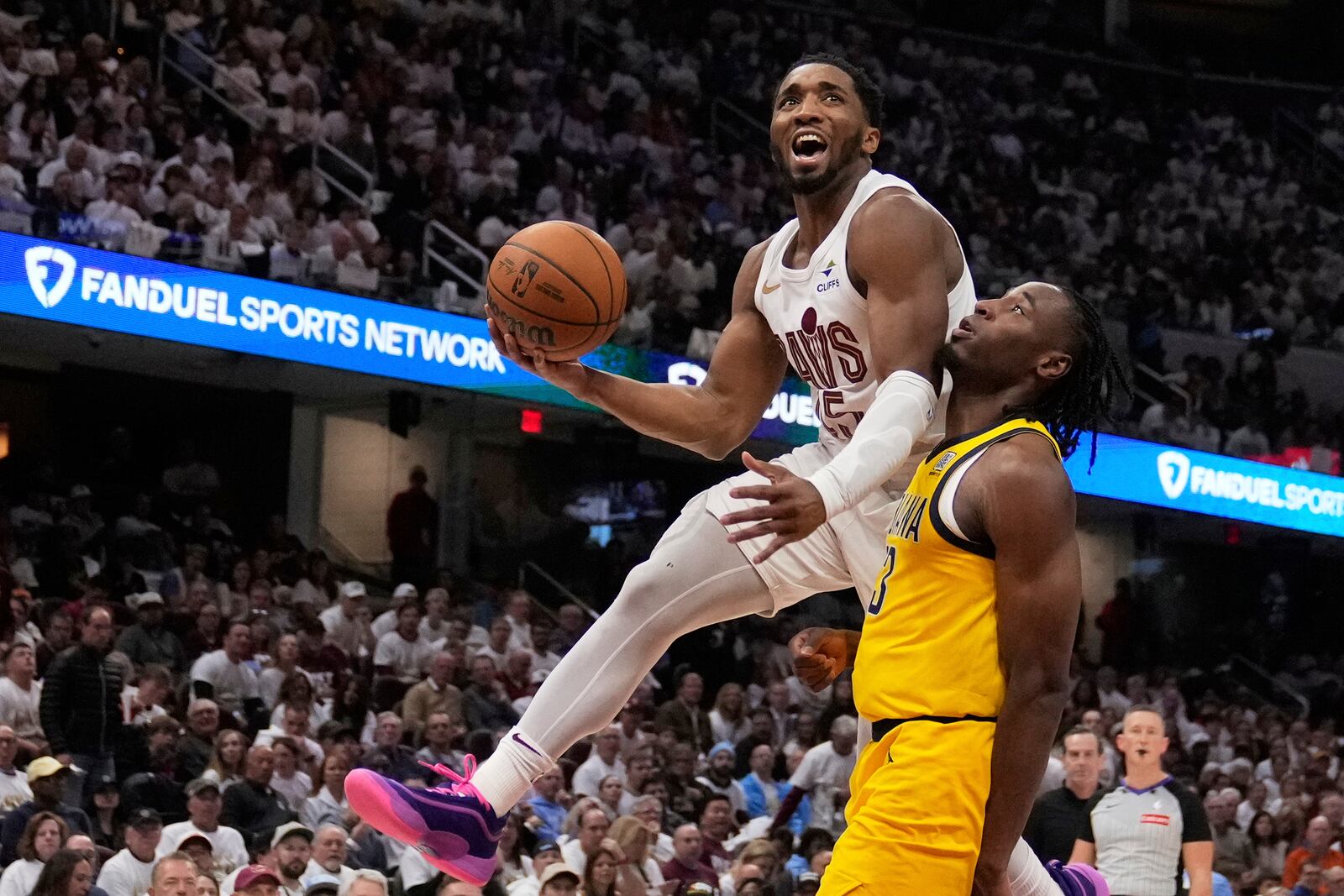 Cleveland Cavaliers guard Donovan Mitchell, left, goes to the basket defended by Indiana Pacers forward Aaron Nesmith, right, in the second half during Game 2 in the Eastern Conference semifinals of the NBA basketball playoffs Tuesday, May 6, 2025, in Cleveland. (AP Photo/Sue Ogrocki)