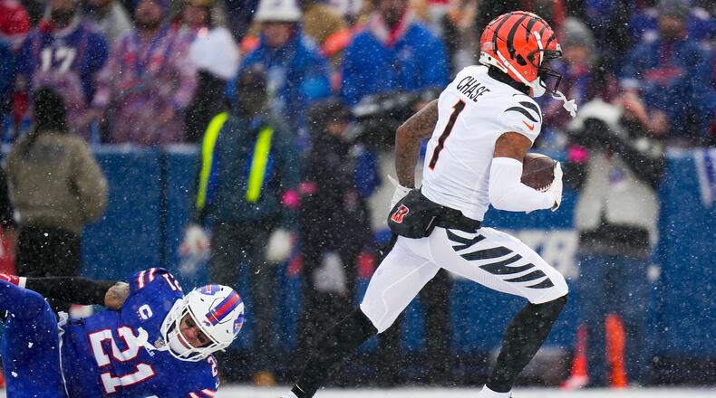 Cincinnati Bengals wide receiver Ja'Marr Chase (1) runs in a touchdown after catching a pass against Buffalo Bills safety Jordan Poyer (21) during the first quarter of an NFL division round football game, Sunday, Jan. 22, 2023, in Orchard Park, N.Y. (AP Photo/Seth Wenig)