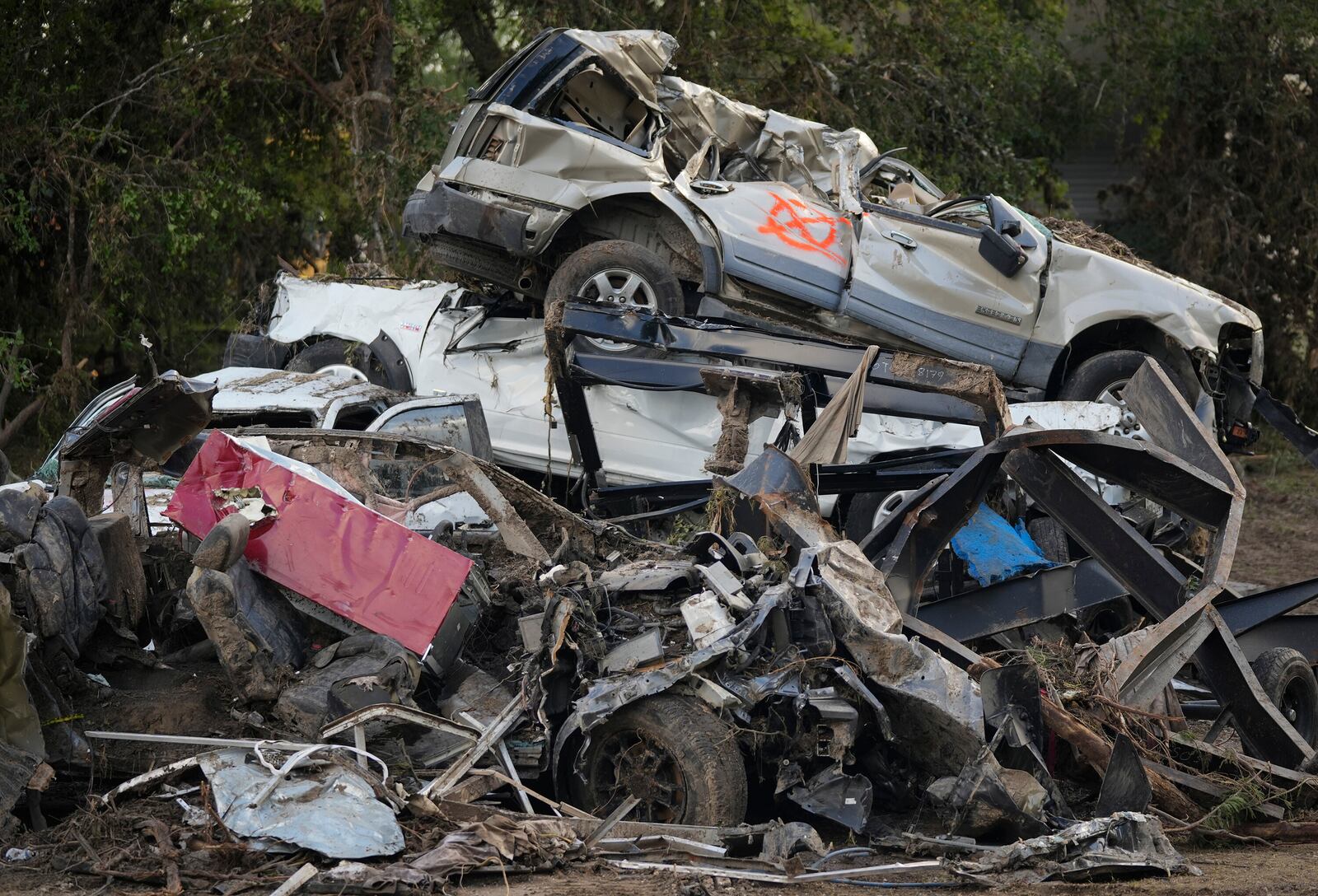 Vehicles are stacked on top of each other on the banks of the Guadalupe River in Ingram, Texas, Tuesday, July 8, 2025, after the Fourth of July flood. (Jay Janner/Austin American-Statesman via AP)