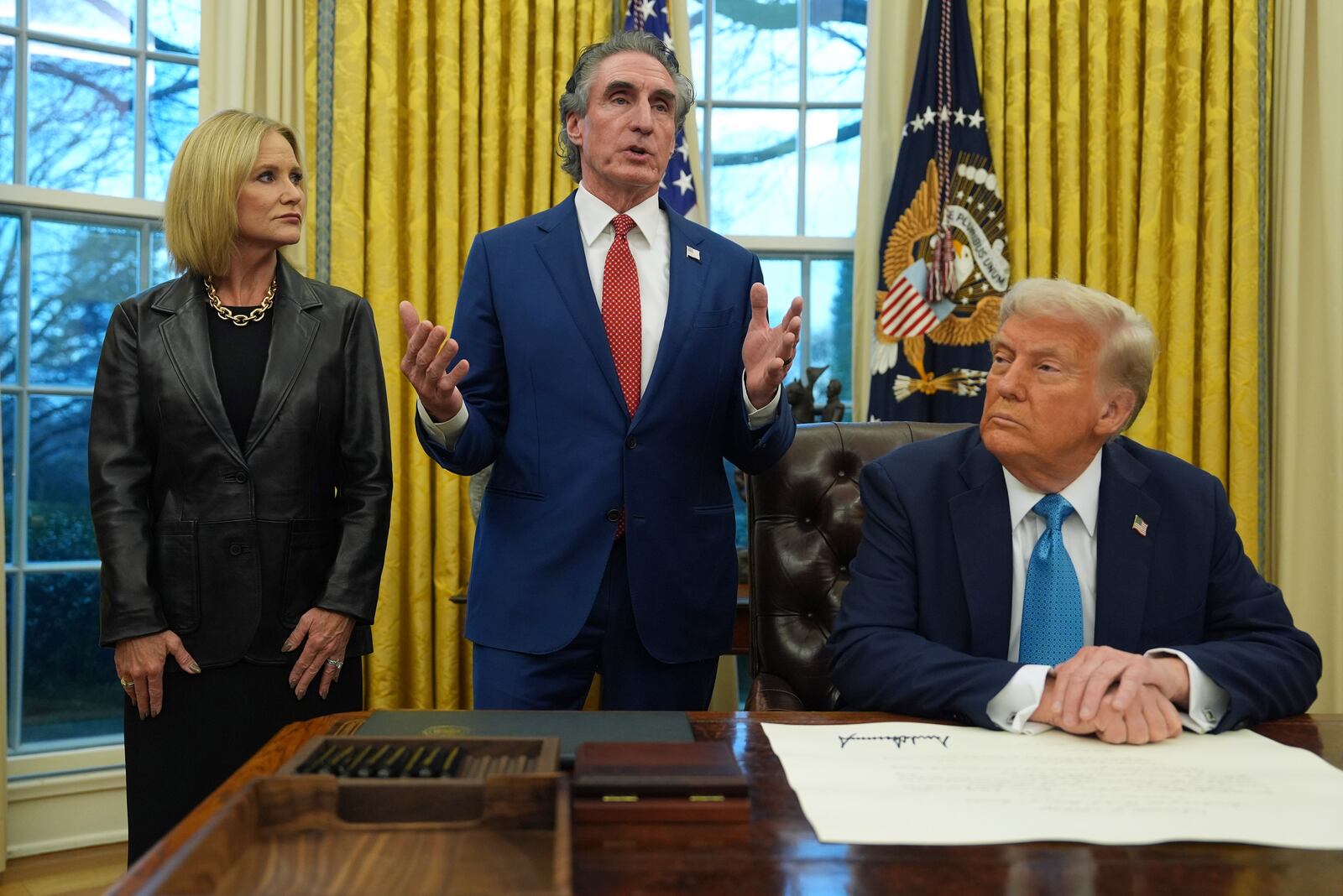 FILE - Interior Secretary Doug Burgum speaks as his wife, Kathryn, and President Donald Trump listen, in the Oval Office of the White House, Friday, Jan. 31, 2025, in Washington. (AP Photo/Evan Vucci,File)