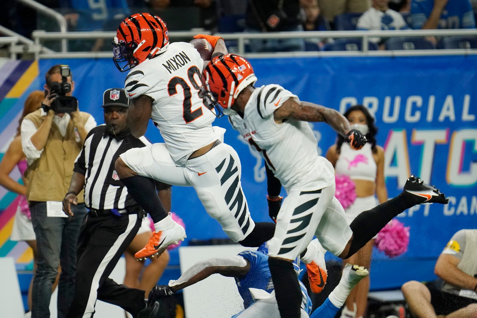 Cincinnati Bengals running back Joe Mixon (28) jumps over Detroit Lions safety Will Harris (25) for a touchdown during the second half of an NFL football game, Sunday, Oct. 17, 2021, in Detroit. (AP Photo/Paul Sancya)