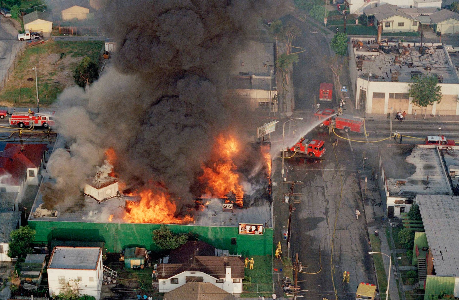 FILE - A fire burns out of control at the corner of 67th Street and West Boulevard in South Central Los Angeles, on April 30, 1992. (AP Photo/Paul Sakuma, File)