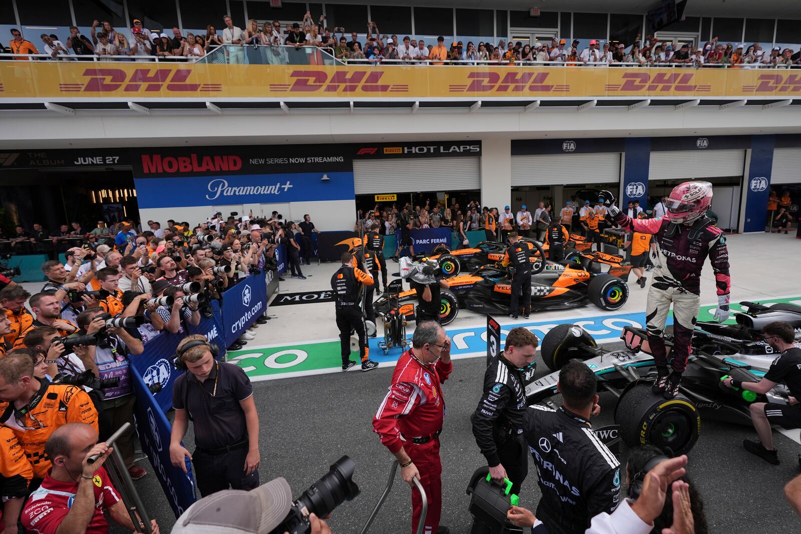 Mercedes driver George Russell of Britain, right, stands on top of his car after a third place finish in the Formula One Miami Grand Prix auto race Sunday, May 4, 2025, in Miami Gardens. Fla. (AP Photo/Rebecca Blackwell)