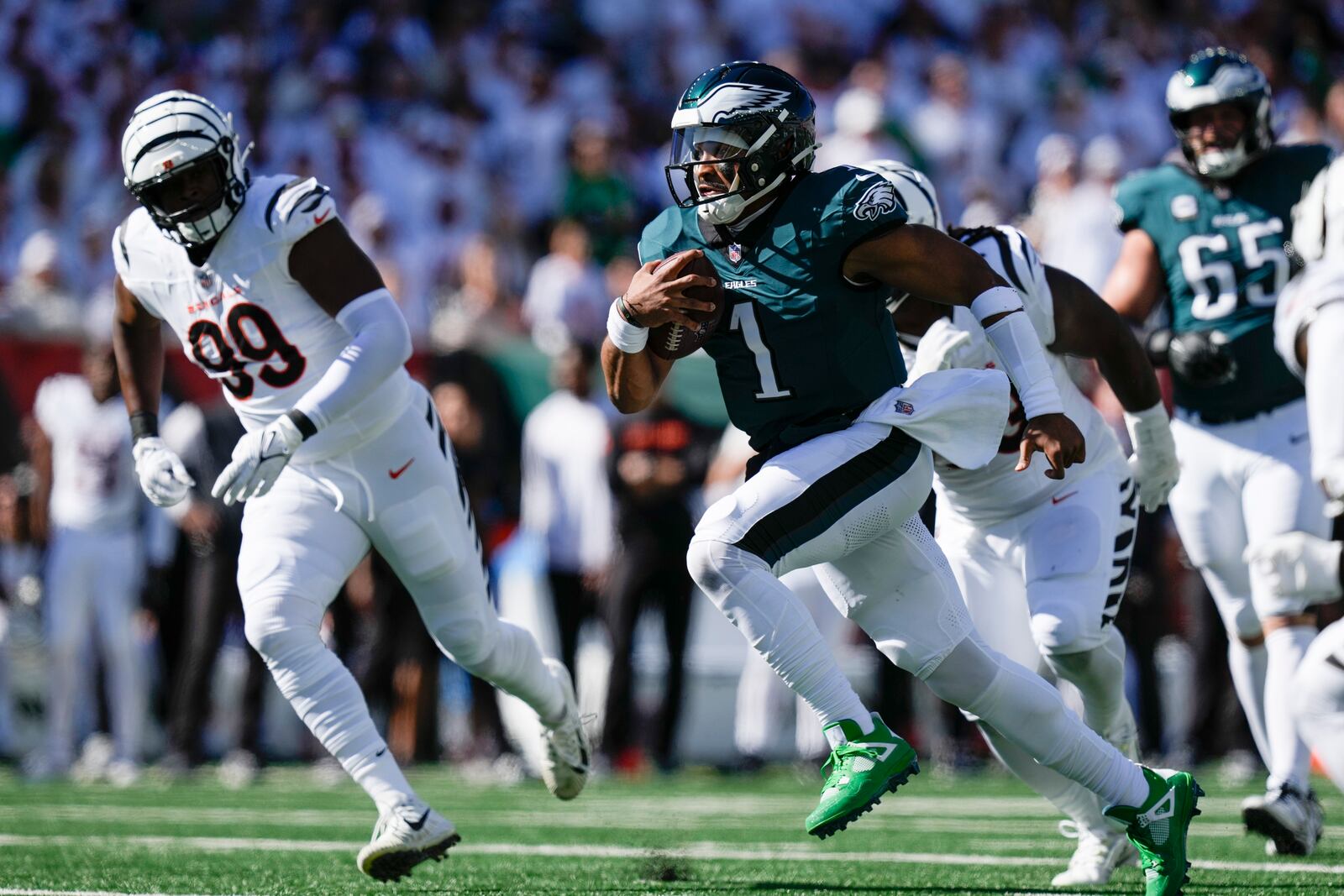 Philadelphia Eagles quarterback Jalen Hurts (1) runs for yardage as Cincinnati Bengals defensive end Myles Murphy (99) tries to stop him during the first half of an NFL football game, Sunday, Oct. 27, 2024 in Cincinnati. (AP Photo/Carolyn Kaster)