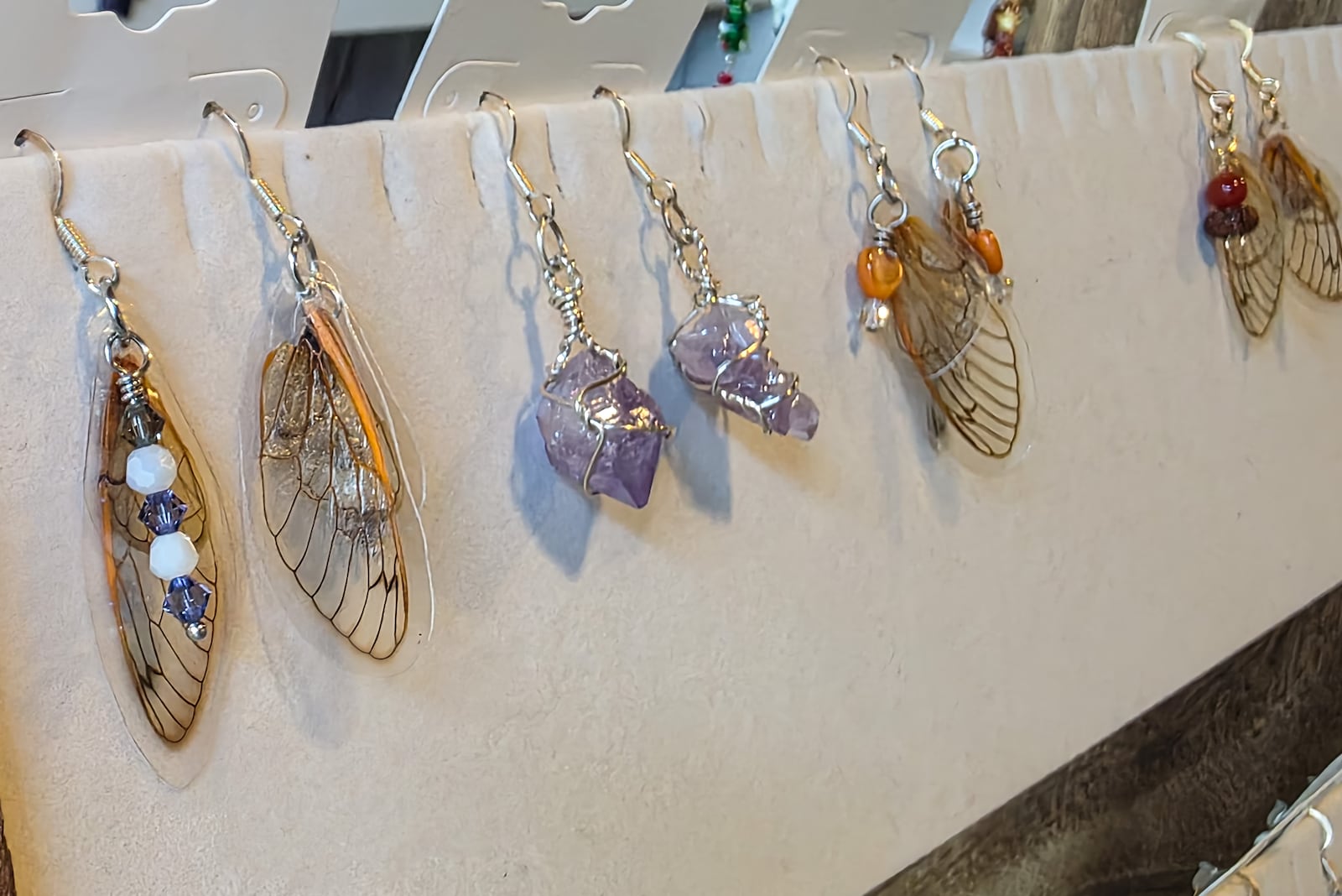 Kathi McQueen, owner of Charm & Crystal Wire Wrapped Jewelry, makes earrings made of real cicada wings, which she collects in the summer, and butterfly wings, which she sources from a butterfly house. NICK GRAHAM/STAFF