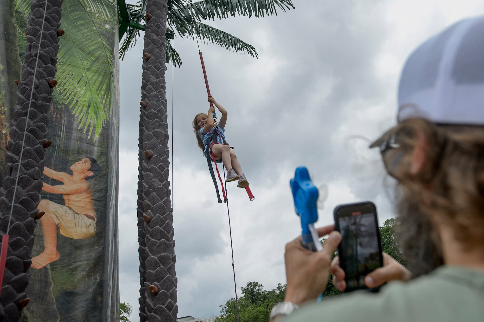 Vivian Davis, 7, of Hartsville, Tenn., makes her way down from the Coconut Tree Climb during the festival event to honor the Army's 250th anniversary, coinciding with President Donald Trump's 79th birthday, Saturday, June 14, 2025, on the National Mall in Washington. (AP Photo/Rod Lamkey, Jr.)