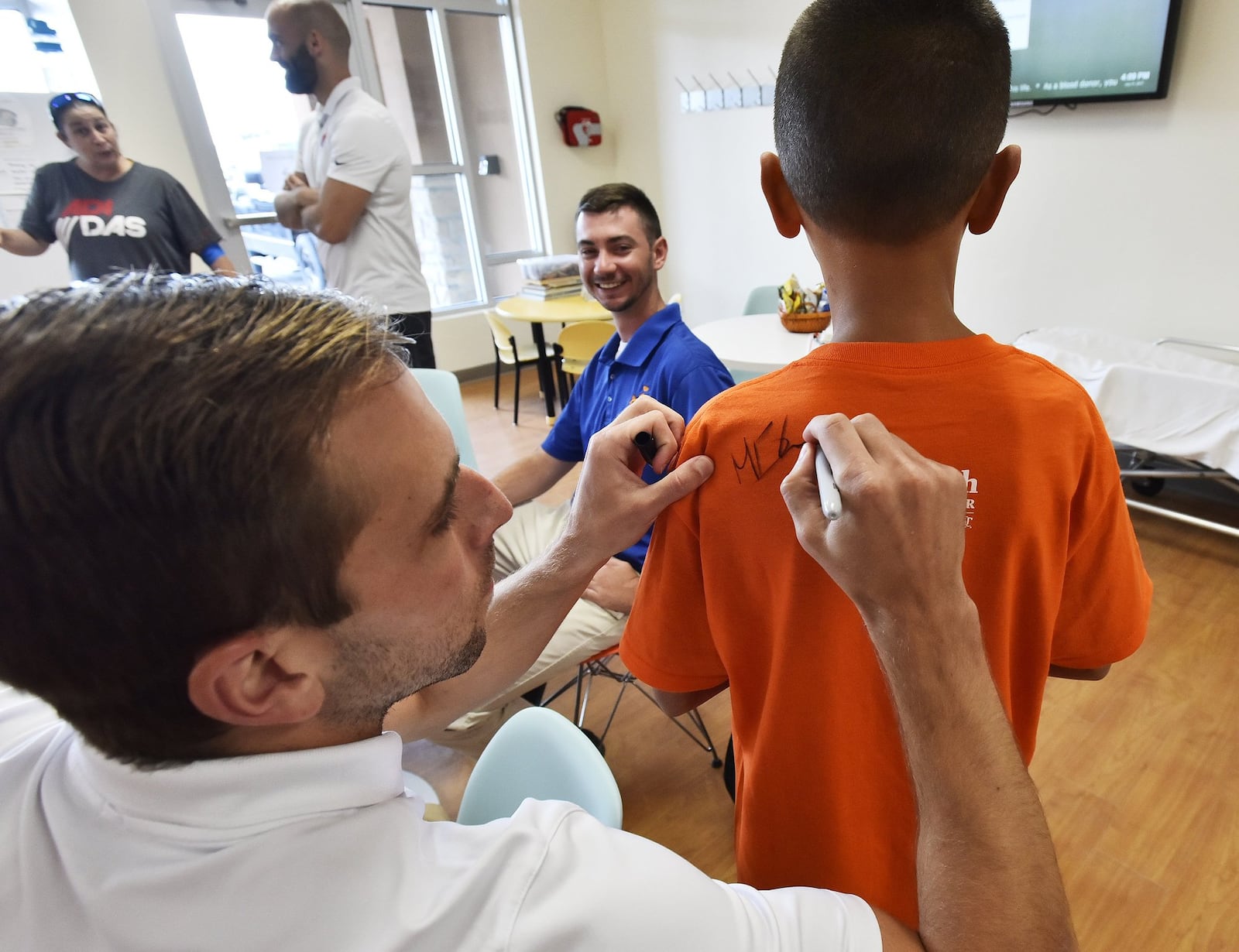 FC Cincinnati player Matt Bahner signs the shirt of Daniel Wattenhofer Jr. at Hoxworth Blood Center on Kingland Drive in West Chester Twp. Hoxworth has partnered with FC Cincinnati for a blood drive to increase awareness for the need for blood donors. Each donor during “FC Cincinnati Week” will get an FC Cincinnati shirt. NICK GRAHAM/STAFF