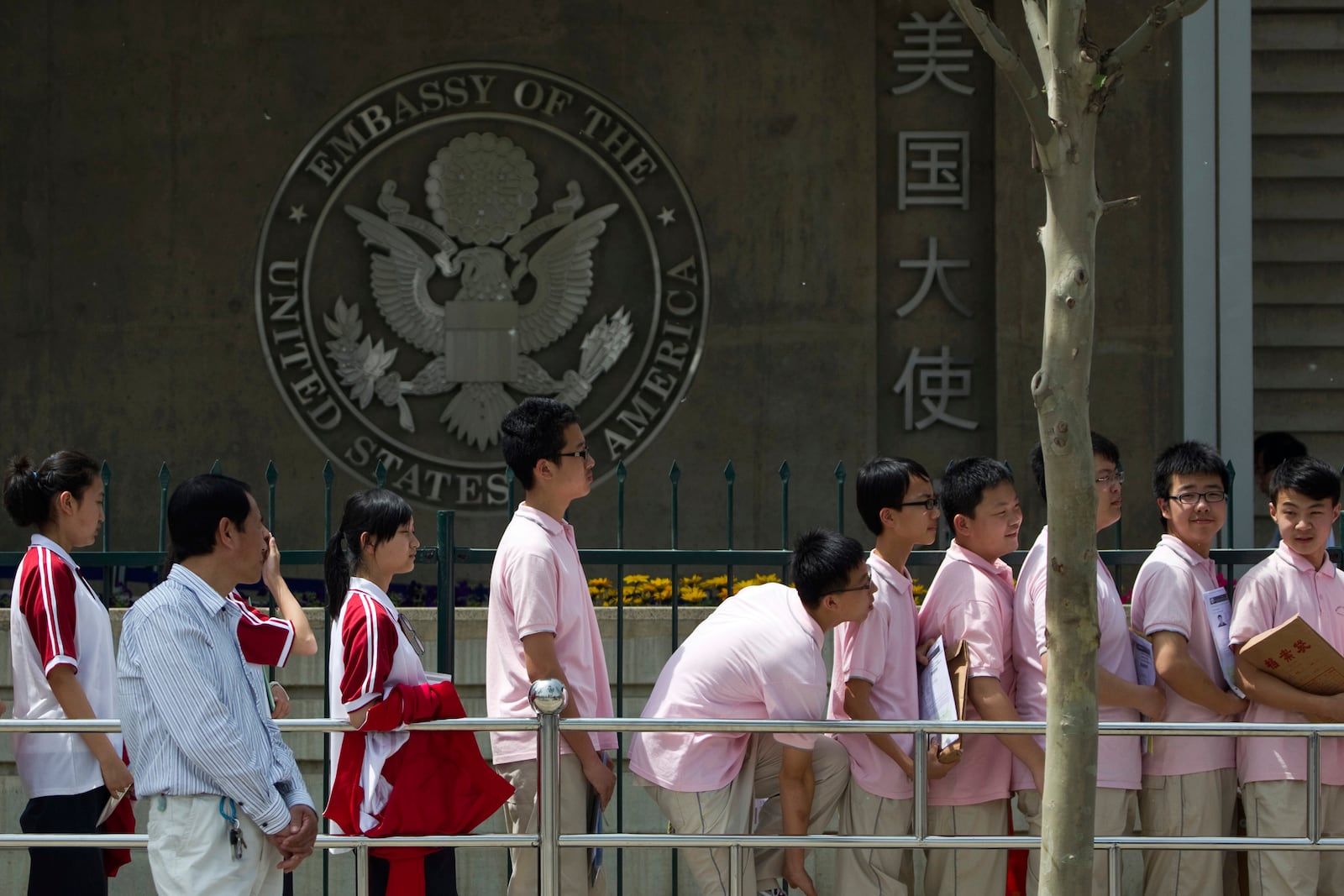 FILE - Chinese students wait outside the U.S. Embassy for their visa application interviews, in Beijing on May 2, 2012. (AP Photo/Alexander F. Yuan, File)