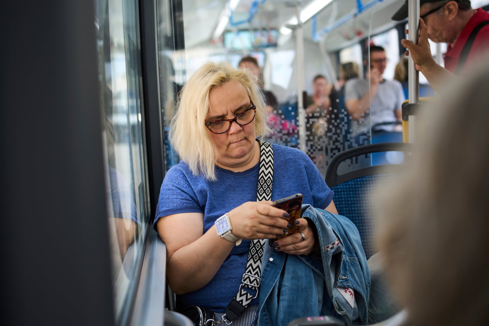 A woman riding a bus looks at her phone in Moscow on Wednesday, July 16, 2025. (AP Photo/Alexander Zemlianichenko)