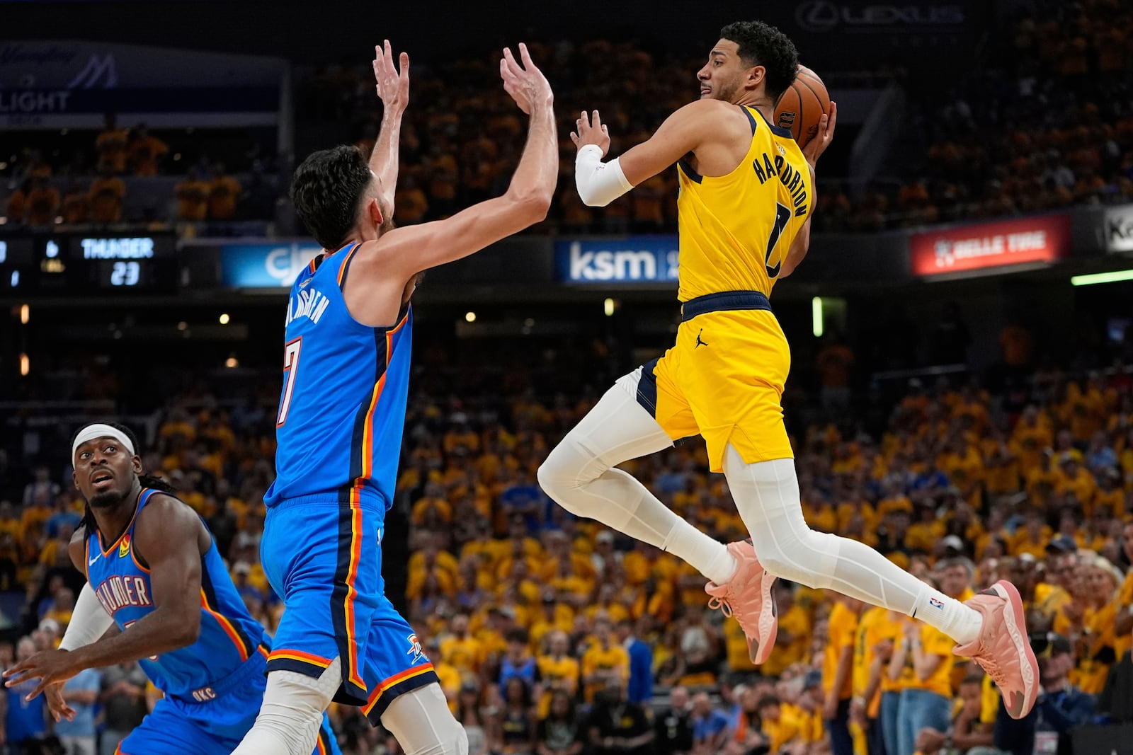 Indiana Pacers guard Tyrese Haliburton, right, passes over Oklahoma City Thunder forward Chet Holmgren (7) during the first half of Game 6 of the NBA Finals basketball series, Thursday, June 19, 2025, in Indianapolis. (AP Photo/Abbie Parr)