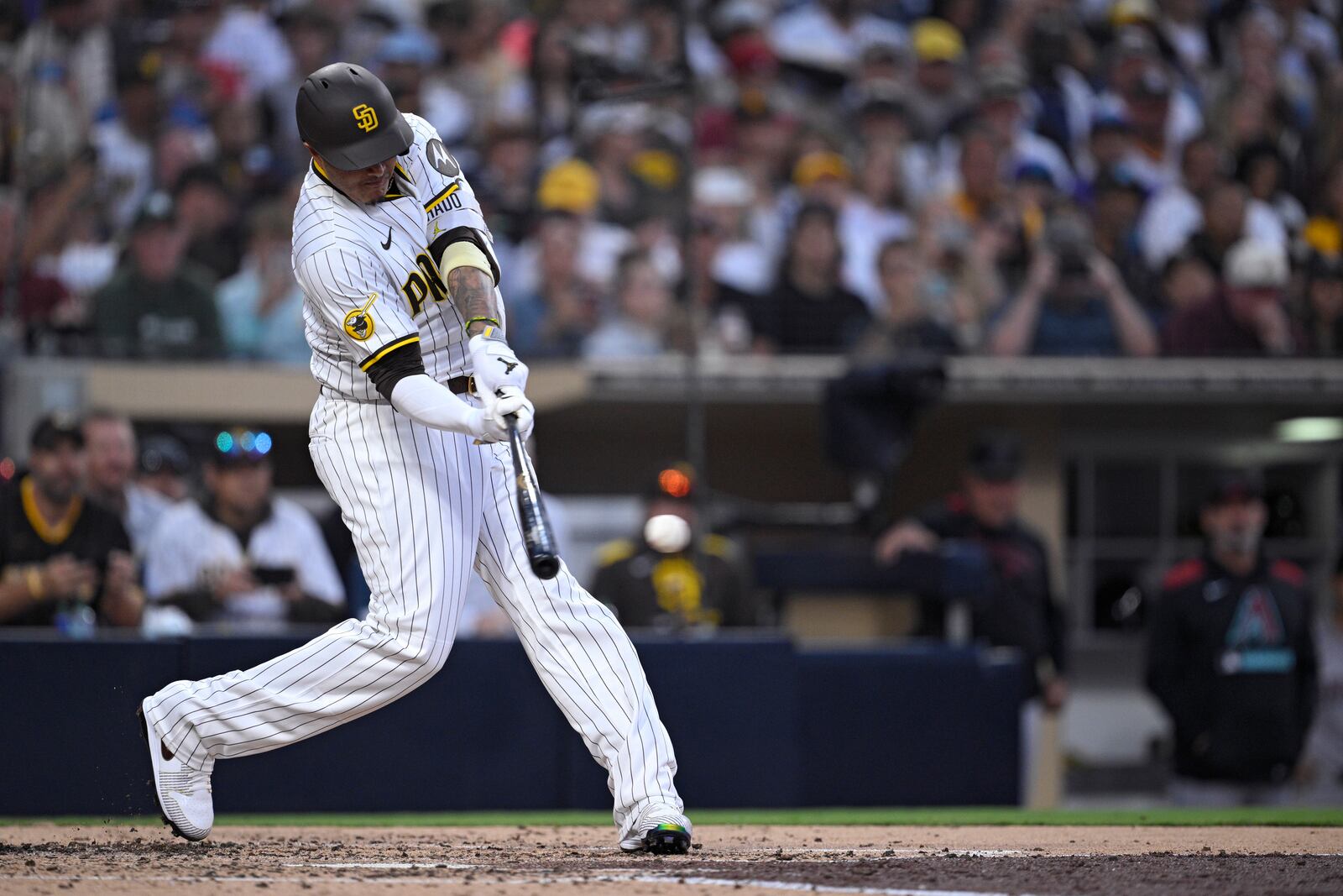 San Diego Padres' Manny Machado hits a single, his 2000th career hit, during the fourth inning of a baseball game against the Arizona Diamondbacks Monday, July 7, 2025, in San Diego. (AP Photo/Orlando Ramirez)