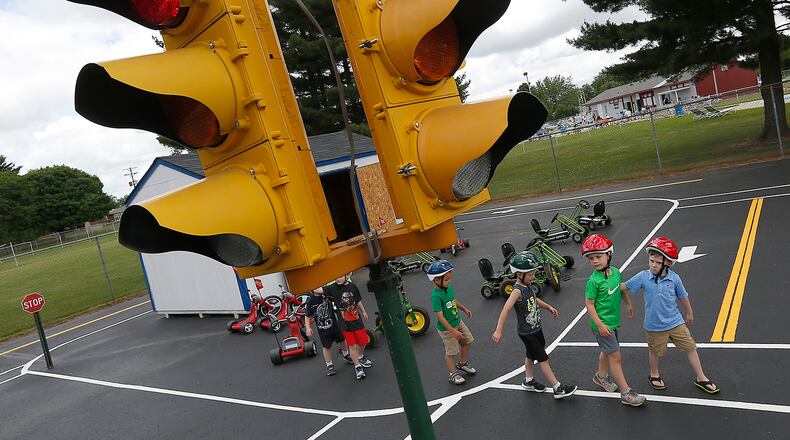 In this 2016 file photo, children learn to cross the street in a crosswalk among other safety lessons at an area Safety Town. The program, which teaches children how to safely cross roads, ride in a car, obey traffic signs and signals, and how to react to fires, will be coming to Monroe this summer for the first time. BILL LACKEY/STAFF