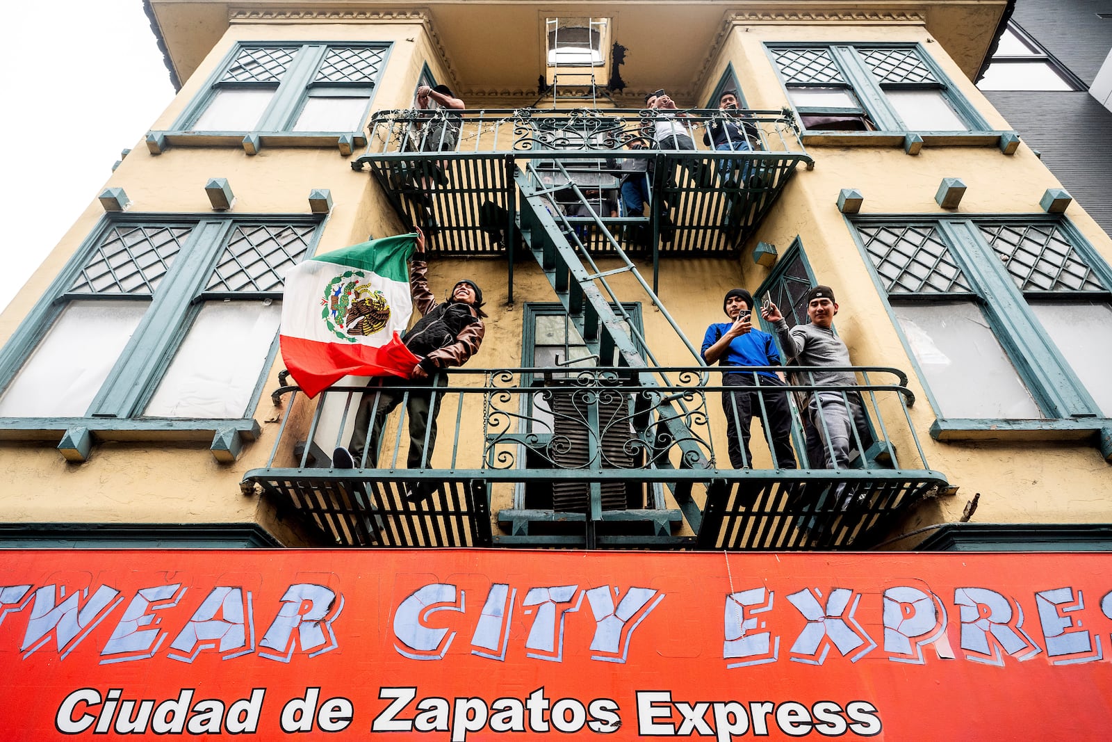 A man waves a Mexican flag as protesters against U.S. Immigration & Customs Enforcement raids march through San Francisco's Mission district on Monday, June 9, 2025. (AP Photo/Noah Berger)