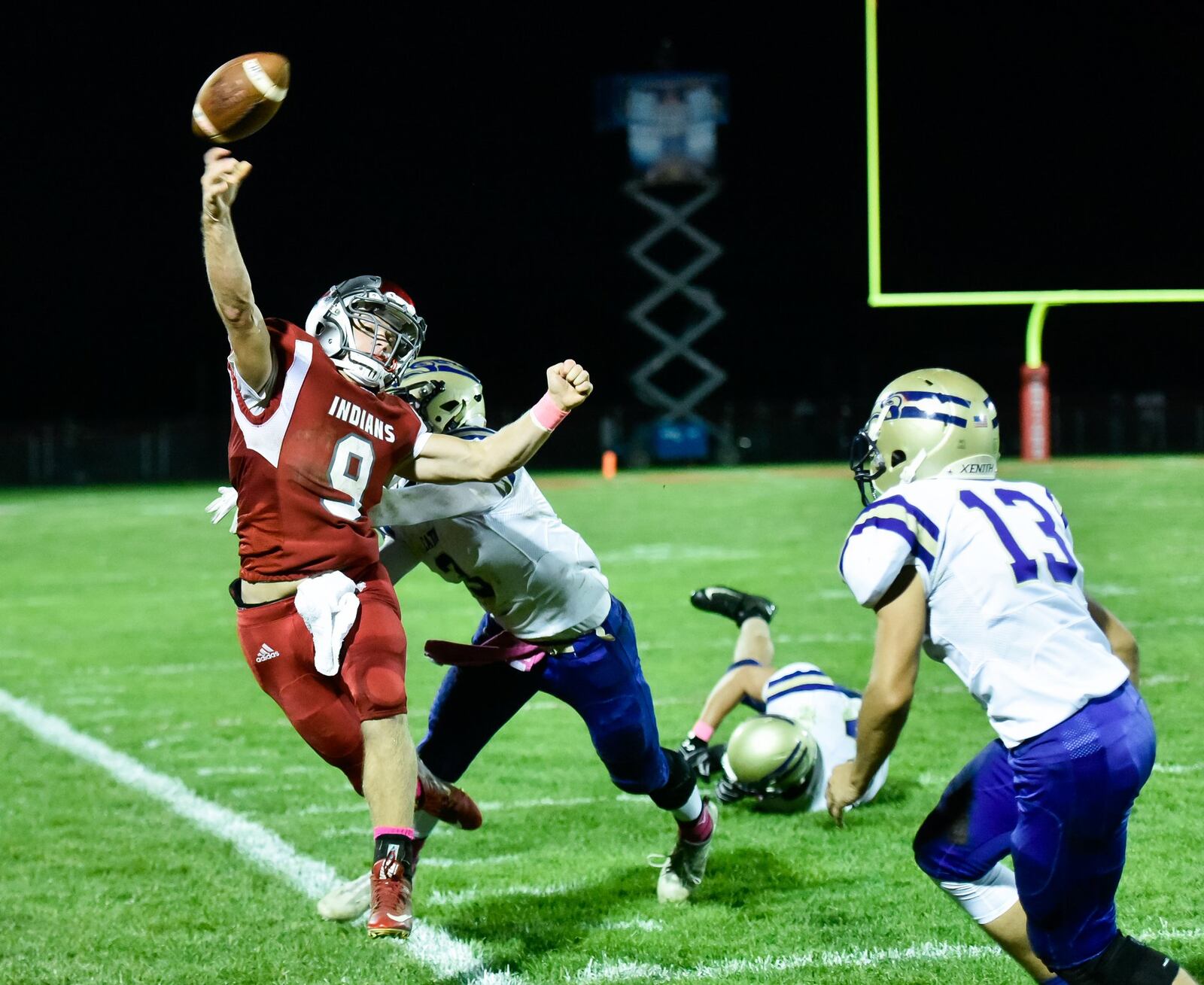 Eaton’s Jordan Lewis (3) and Jarod Lee (13) pressure Carlisle quarterback Jake Moore on the sideline during Thursday night’s game at Laughlin Field in Carlisle. NICK GRAHAM/STAFF