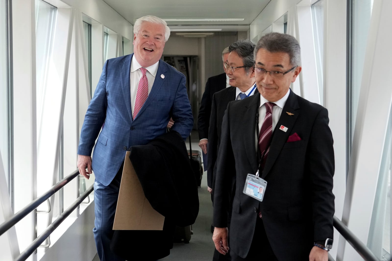 U.S. Ambassador to Japan George Glass, left, is escorted by Victor Osumi, right, president of Japan Operations of Delta, upon his arrival at Haneda Airport in Tokyo Friday, April 18, 2025. (Kazuhiro Nogi/Pool Photo via AP)