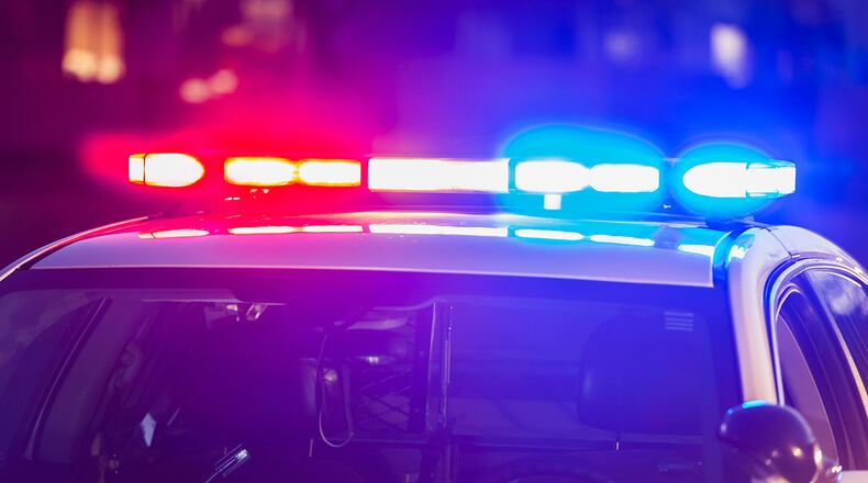 The roof of a police patrol car at night, with the blue and red lights flashing.