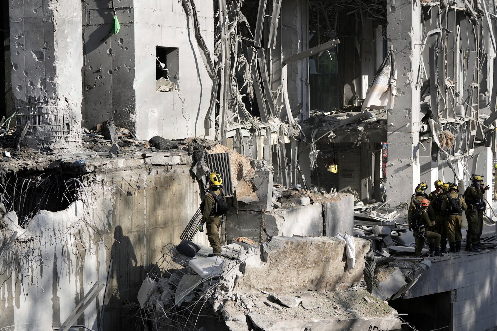 Rescue workers and military personnel inspect the site of a direct hit from an Iranian missile strike in Ramat Gan, Israel, Thursday, June 19, 2025. (AP Photo/Oded Balilty)