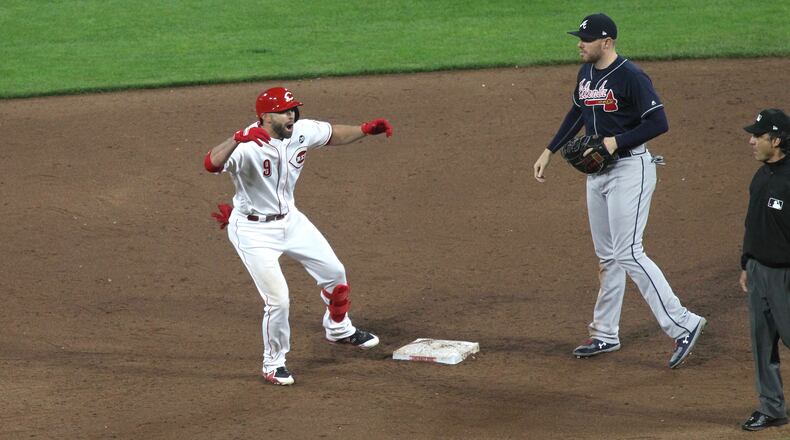 The Reds’ Jose Peraza celebrates after a two-run double in the sixth inning on Tuesday, April 23, 2019, at Great American Ball Park in Cincinnati.