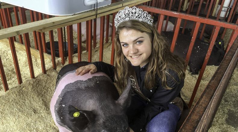Butler County Fair Queen Micayla McClure, 17, of Harrison, with her hog, Dwight, at the fair on Monday, July 23.