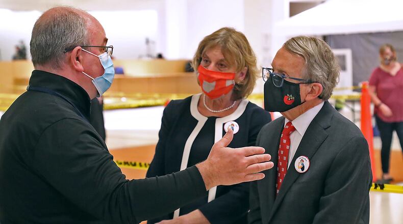 Clark County Health Commissioner Charles Patterson talks with Governor Mike DeWine and his wife, Fran, during a tour of the Clark County COVID vaccine distribution center at the Upper Valley Mall Thursday. BILL LACKEY/STAFF
