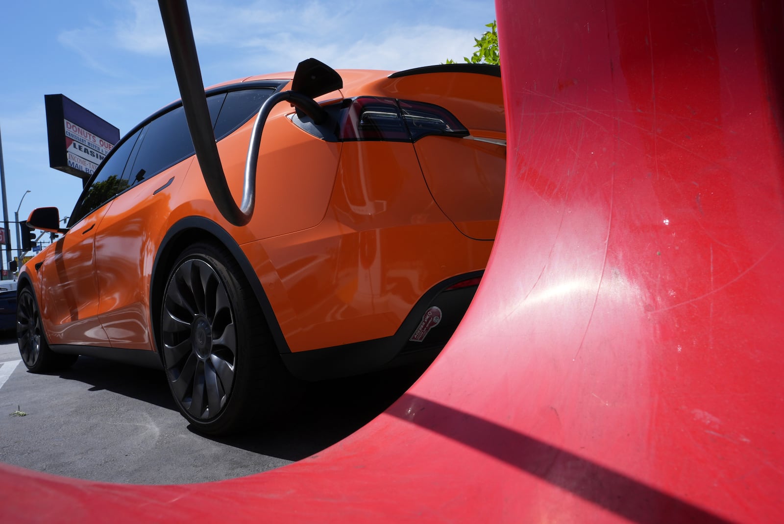 An electric vehicle is seen charging at a charging station Thursday, May 22, 2025, in Long Beach, Calif. (AP Photo/Damian Dovarganes)