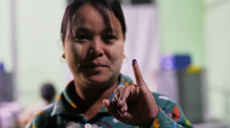 A voter holds up her finger marked with ink indicating she voted at a polling station during the third phase of general election in Mandalay, central Myanmar, Sunday, Jan. 25, 2026. (AP Photo/Aung Shine Oo)