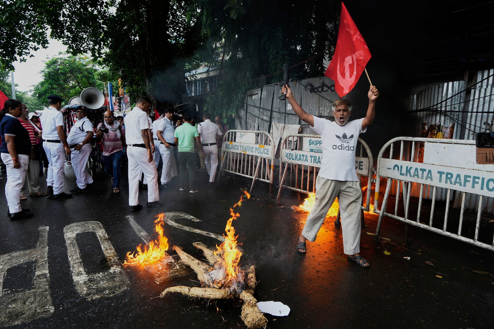 A supporter of Centre of India Trade Unions, CITU, shouts slogans as an effigy of Indian Prime Minister burns during a nation-wide strike to protest what they call the anti-labor and anti-poor policies of the federal government, in Kolkata, India, Wednesday, July 9, 2025. (AP Photo/Bikas Das)