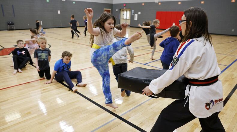 Maci Strickland, 9, practices a kick during a karate class taught by Christina Schul from Budokai Academy of Martial Arts Thursday, March 23, 2023 at Madison Elementary School. Madison offered multiple after school clubs with many filled to capacity. NICK GRAHAM/STAFF