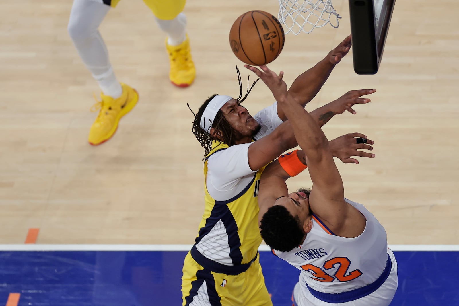 New York Knicks center Karl-Anthony Towns (32) is fouled while shooting by Indiana Pacers center Myles Turner (33) during the second quarter of Game 1 of the NBA basketball Eastern Conference final, Wednesday, May 21, 2025, in New York. (AP Photo/Adam Hunger)