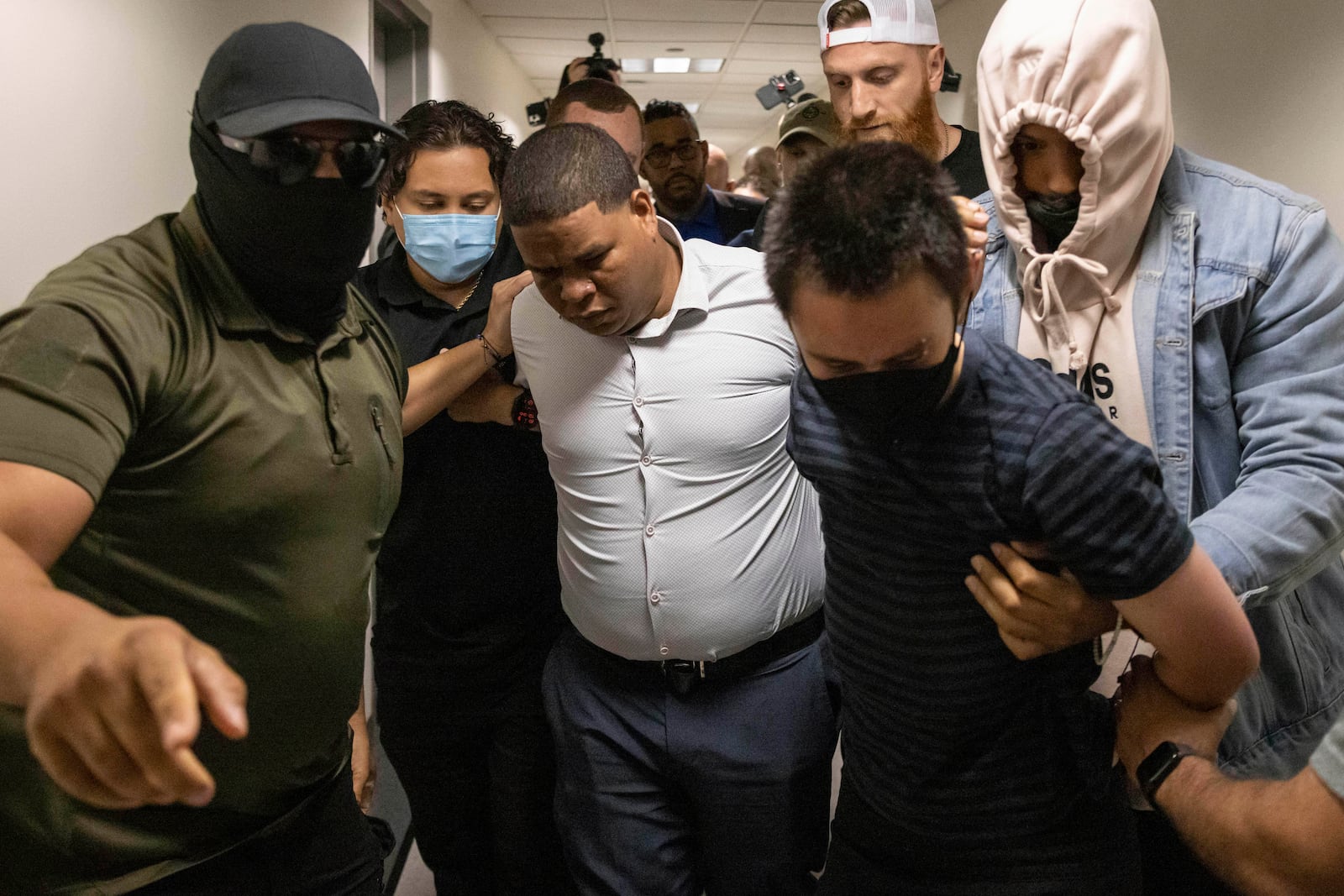 FILE - A Dominican man, center, and an activist, right, are detained by plain clothes officers with Immigration and Customs Enforcement after an immigration hearing at the immigration court inside the Jacob K. Javits Federal Building in New York, June 6, 2025. (AP Photo/Yuki Iwamura, File)