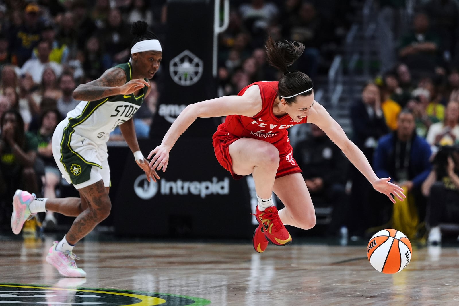Seattle Storm guard Erica Wheeler looks on as Indiana Fever guard Caitlin Clark (22) falls while reaching for the ball during the second half of a WNBA basketball game Tuesday, June 24, 2025, in Seattle. (AP Photo/Lindsey Wasson)