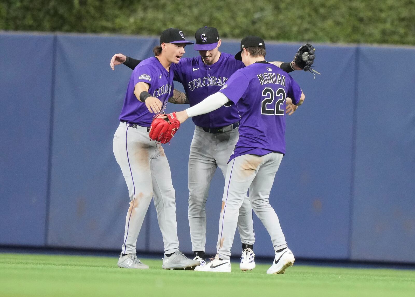 Colorado Rockies left fielder Jordan Beck, left, center fielder Brenton Doyle, center and right fielder Mickey Moniak (22) celebrate after the Rockies defeated the Miami Marlins in a baseball game, Tuesday, June 3, 2025, in Miami. (AP Photo/Lynne Sladky)
