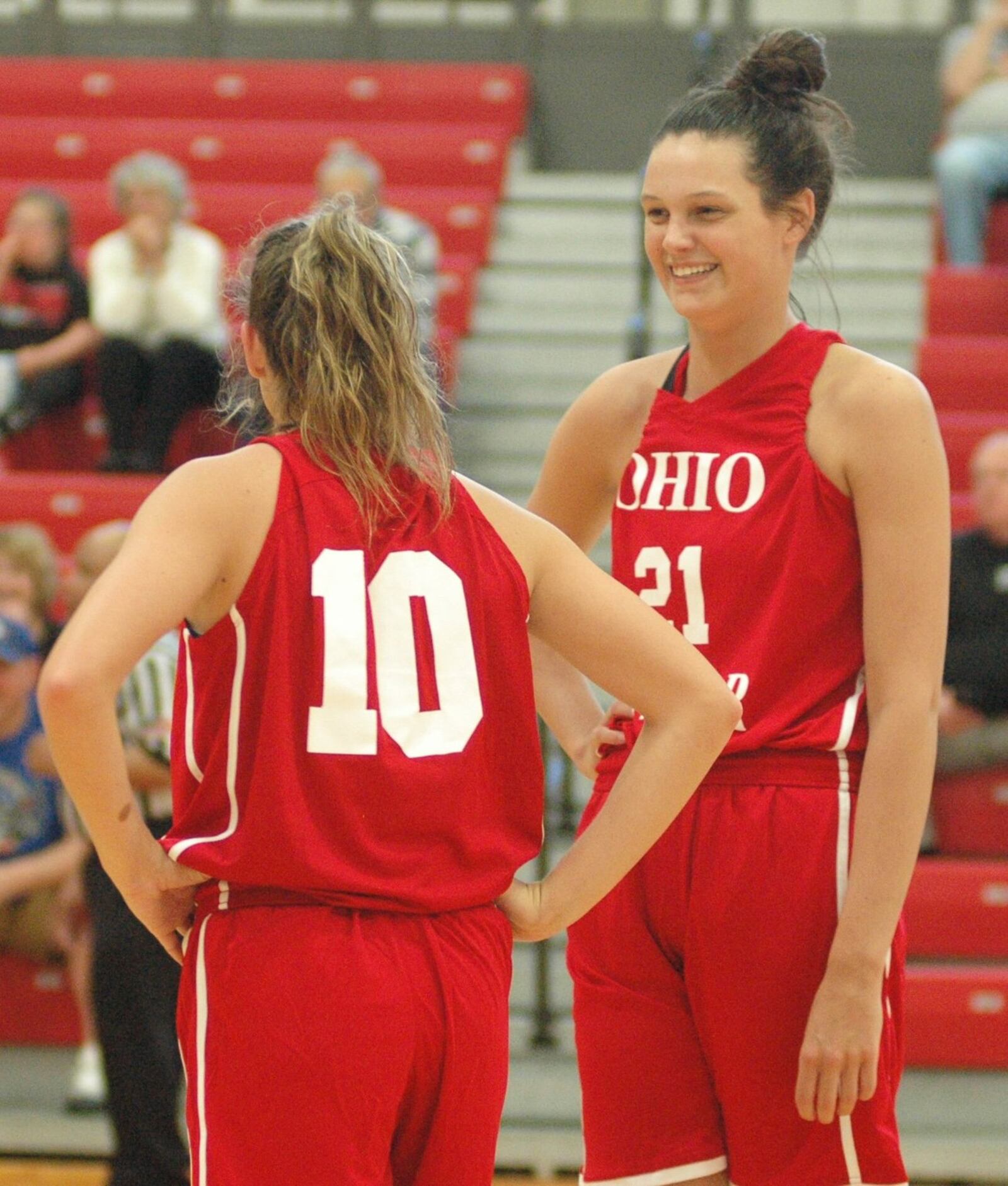 Franklin’s Layne Ferrell (21) shares a light moment with South teammate Kassidy Betzing of Pomeroy Meigs on Friday night during the Ohio High School Basketball Coaches Association North-South Division I-II All-Star Game at Denison University’s Mitchell Center. The South won 131-77. RICK CASSANO/STAFF