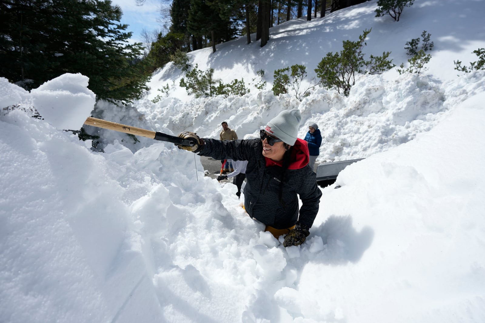 FILE - Monica Tapia, a volunteer with the disaster response group Team Rubicon, digs a resident's vehicle out of the snow, in Lake Arrowhead, Calif., March 8, 2023. (AP Photo/Marcio Jose Sanchez, File)