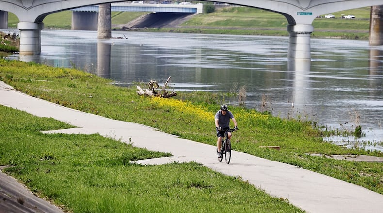 A cyclist rides alimg the Great Miami Ri er in Hamilton. The Hamilton Community Foundation advocated 25 years ago for the extension of the Great Miami River Trail, led by former board chair Dave Belew. This year, the trail in Hamilton is being renamed to honor his legacy. NICK GRAHAM/STAFF