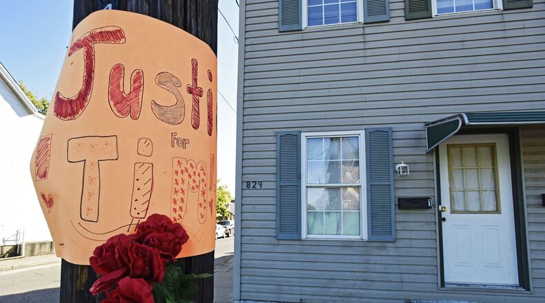 A makeshift memorial is attached to a utility pole outside the home where Tim Dugan was killed in the 800 block of Maple Avenue in Hamilton. NICK GRAHAM/STAFF