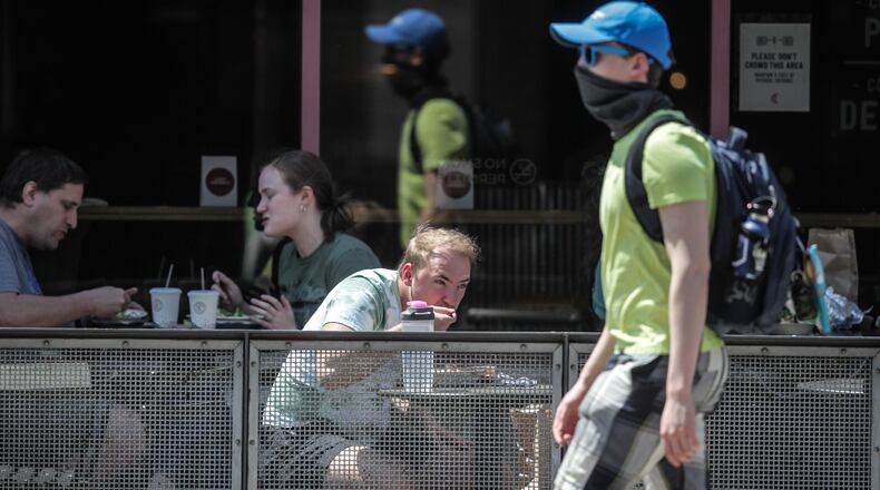 Brown Street was busy on a warm Tuesday afternoon. The Centers for Disease Control and Prevention eased its guidelines Tuesday, April 27, 2021, on the wearing of masks outdoors, saying fully vaccinated Americans don’t need to cover their faces anymore unless they are in a big crowd of strangers. JIM NOELKER/STAFF